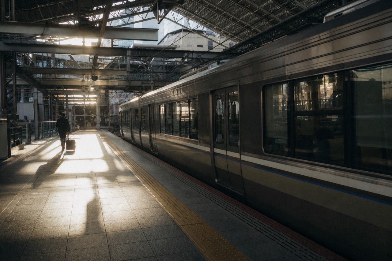 A railway platform in Kyoto with a train waiting under a long roof