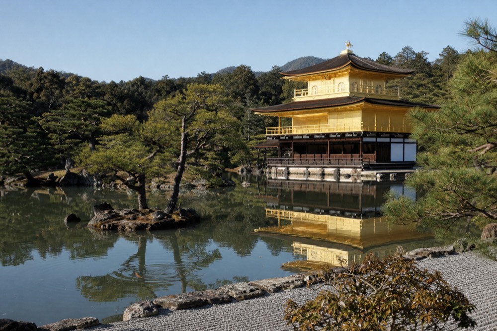 Kinkaku-ji's golden pavilion reflected in the pond on a clear morning