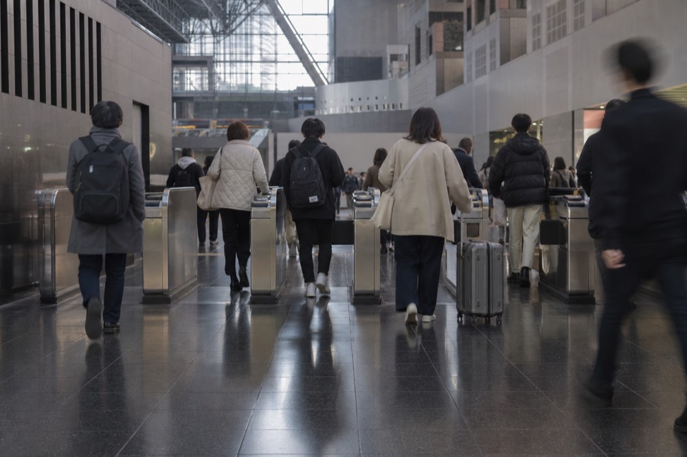 A ticket gate at Kyoto Station with passengers tapping IC cards