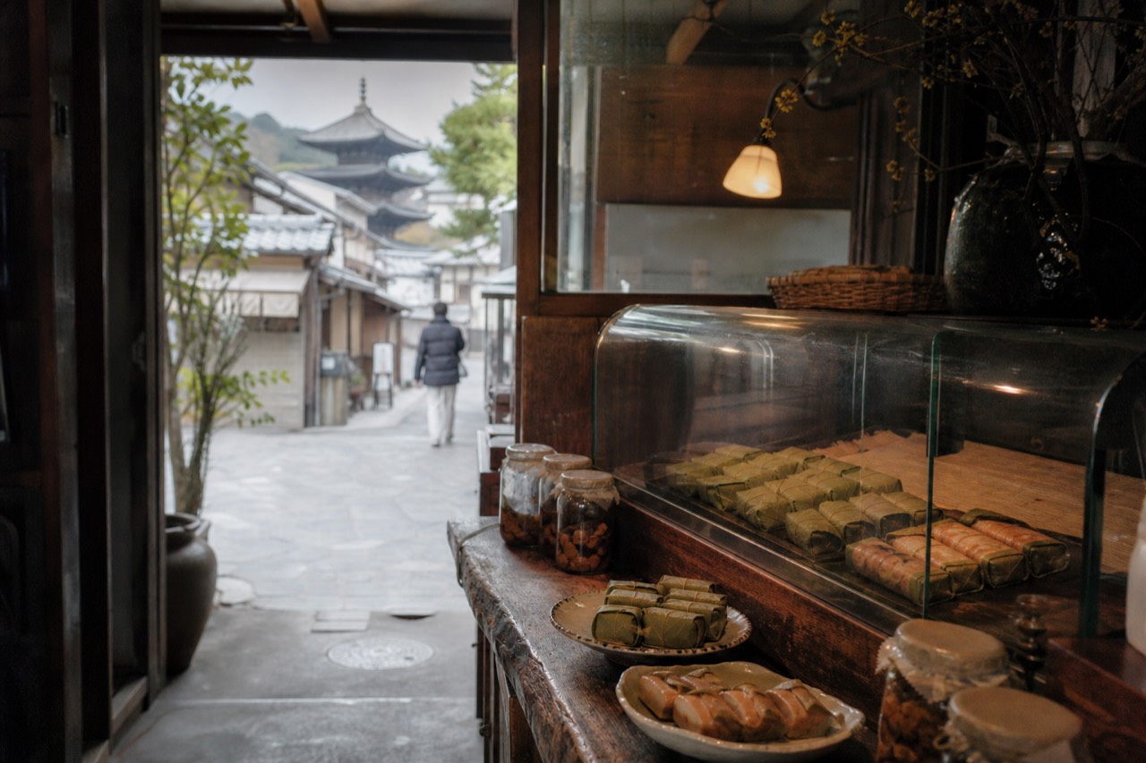 Persimmon-leaf-wrapped sushi and pickles arranged on a wooden counter in a Nara shop