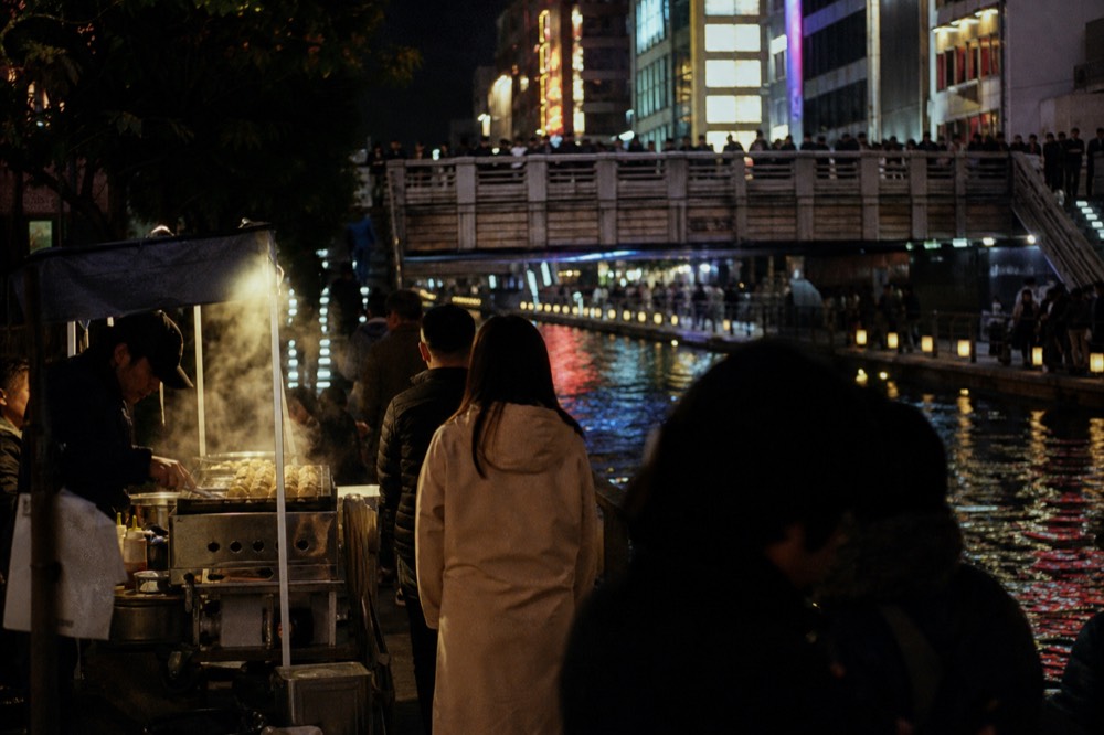The illuminated Dotonbori canal at night with the Glico running man sign and crowds on the bridge