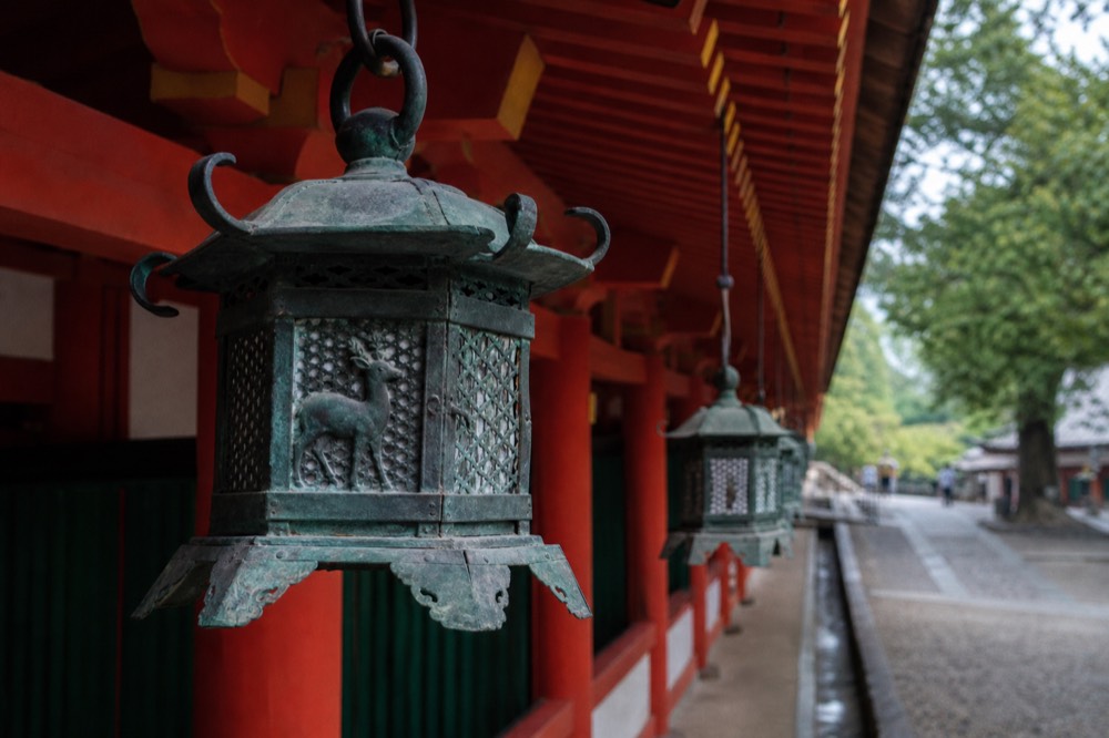 Close-up of a bronze hanging lantern with deer motif on the shrine corridor