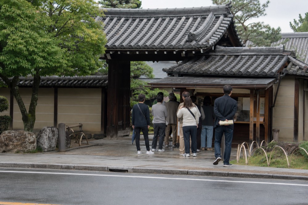 Ticket window and entrance gate of a Kyoto temple with visitors queuing
