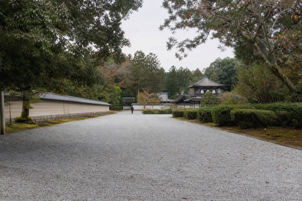 Gravel courtyard and low-roofed palace buildings inside a walled park