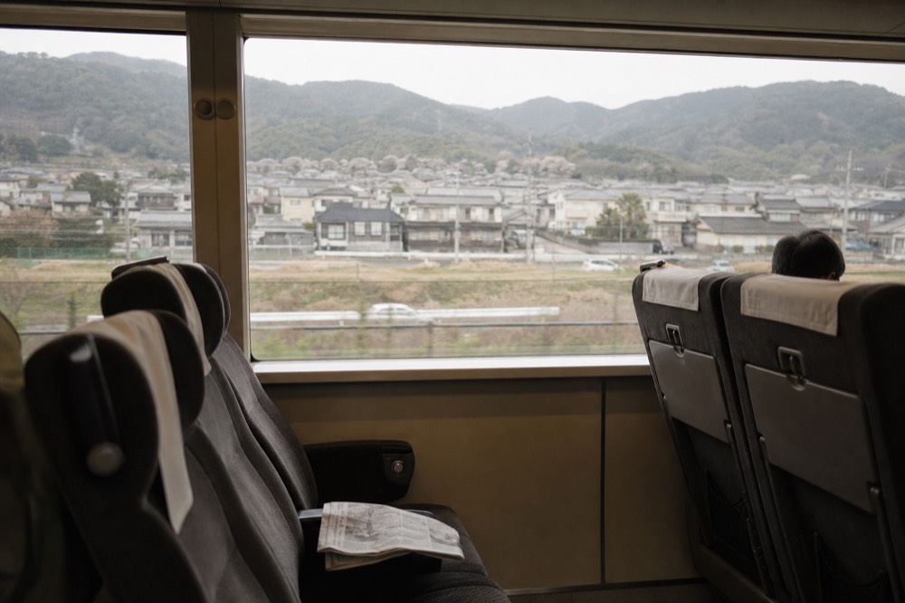A railway carriage interior with reserved seating rows and large windows