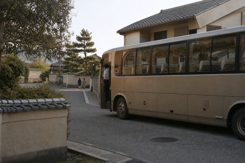 A touring coach parked on a city street with rows of seats visible through the windows