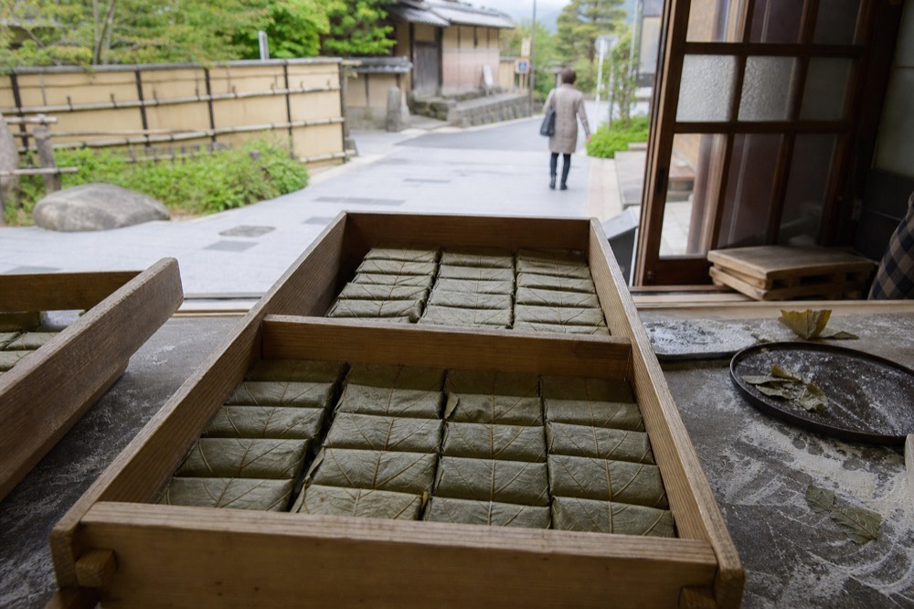 Trays of persimmon-leaf-wrapped sushi pressed in a wooden box